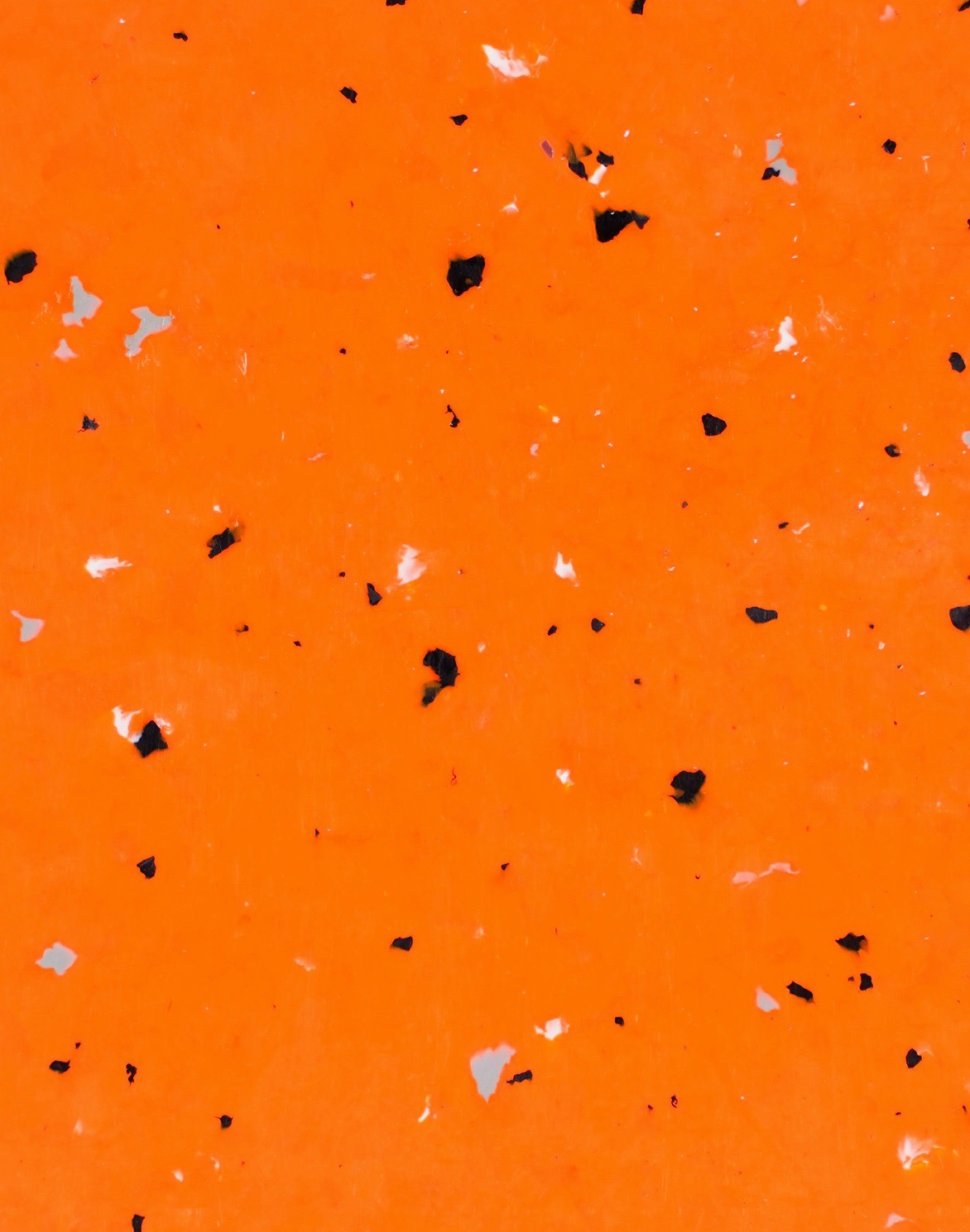 granité orange avec morceaux noirs en moyenne quantité, quelques gris et quelques blancs